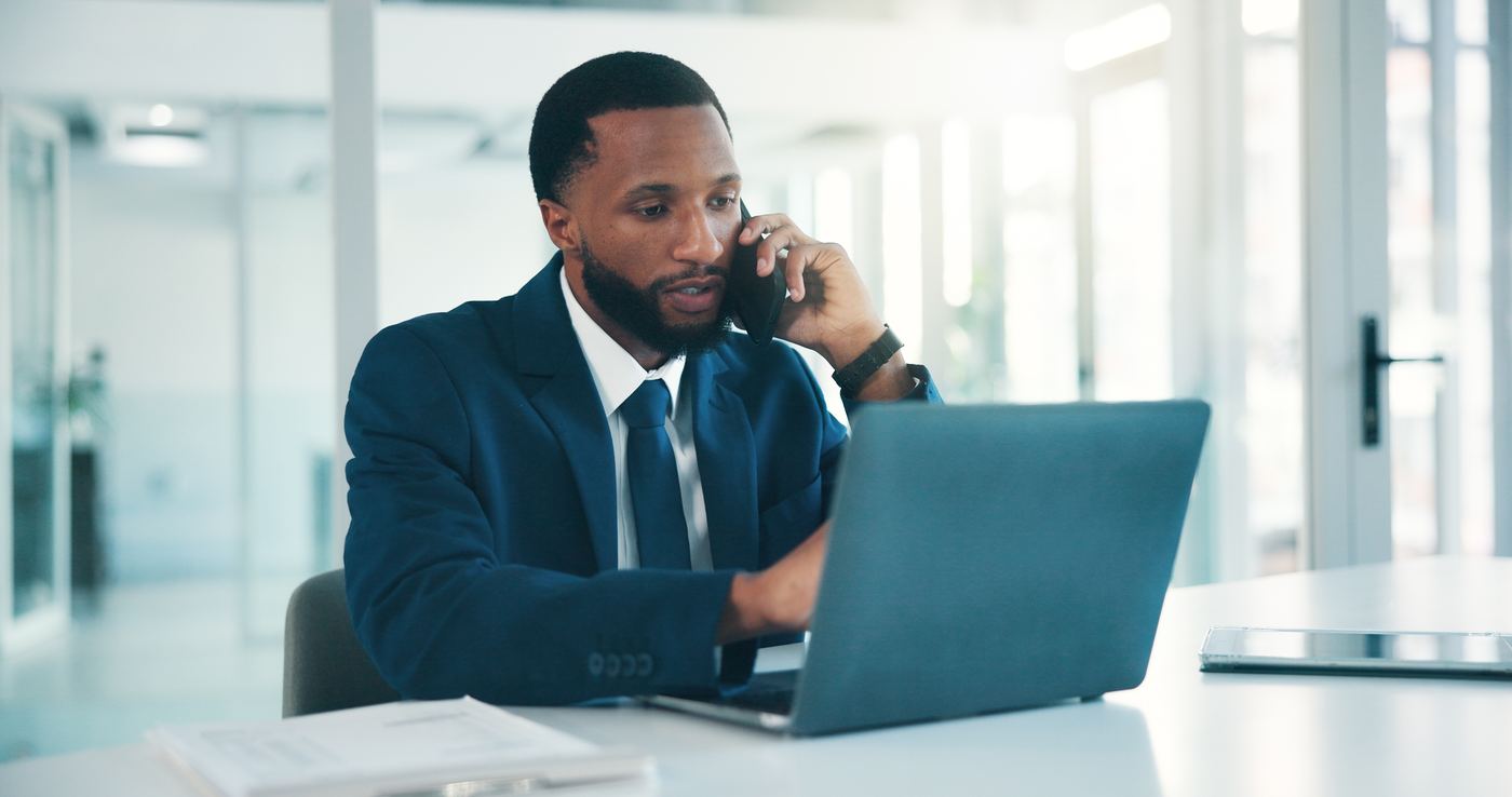 Business owner on a phone call while working on his laptop